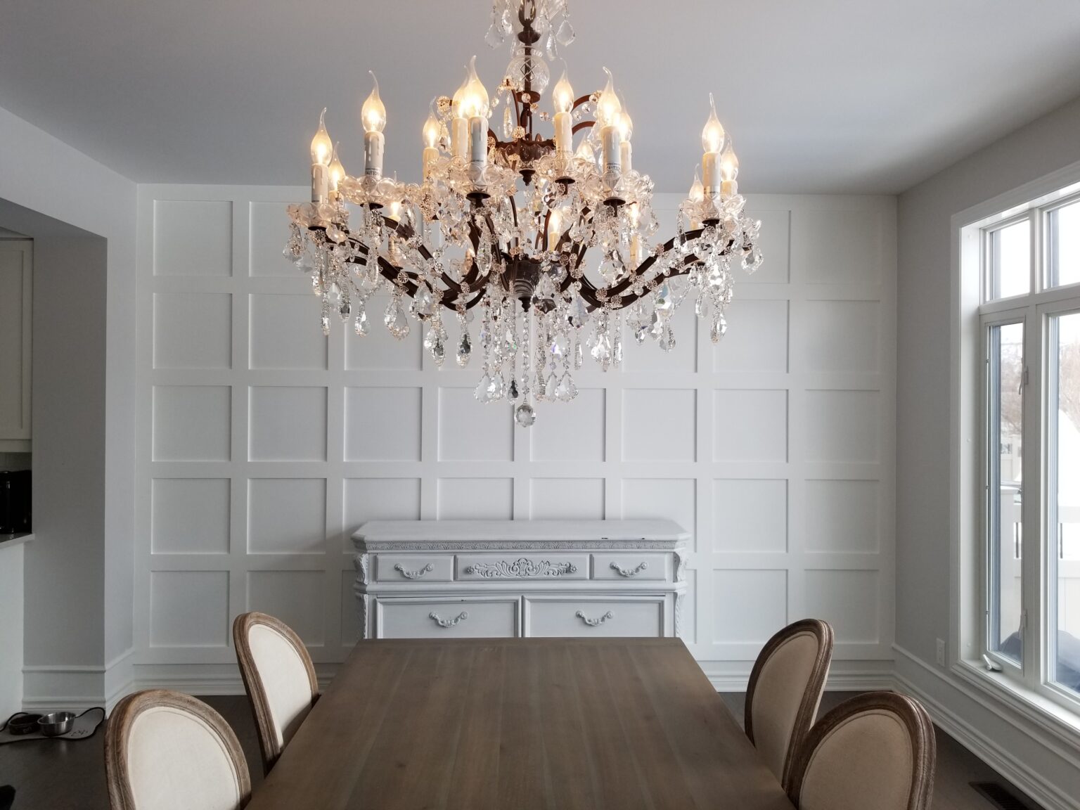 Dining room with wainscoting and crystal chandelier