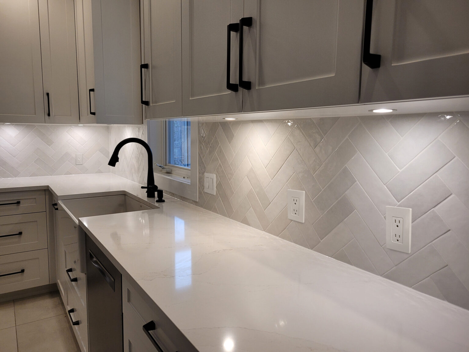 Kanata kitchen with white quartz counters and herringbone tile backsplash